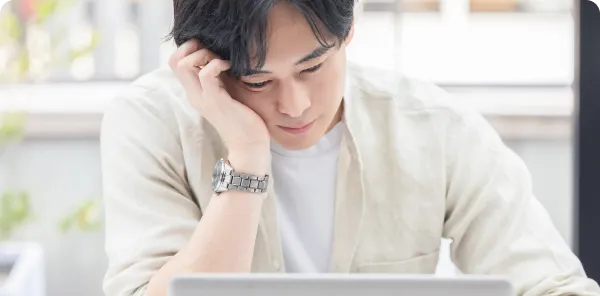 パソコンの前で頭を抱える男性