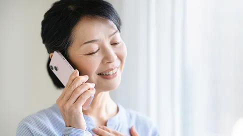 笑顔で電話相談に応じる女性